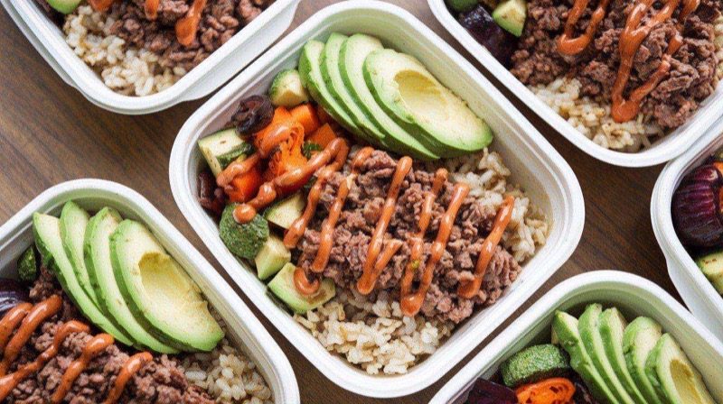 Korean-style ground beef power bowl with white rice, glistening glazed beef, pickled cucumber, and a sunny-side-up egg on top