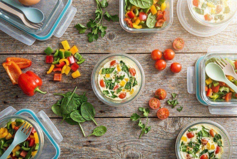 Fluffy egg white cup in a mug with spinach, tomato, and melted mozzarella cheese on top