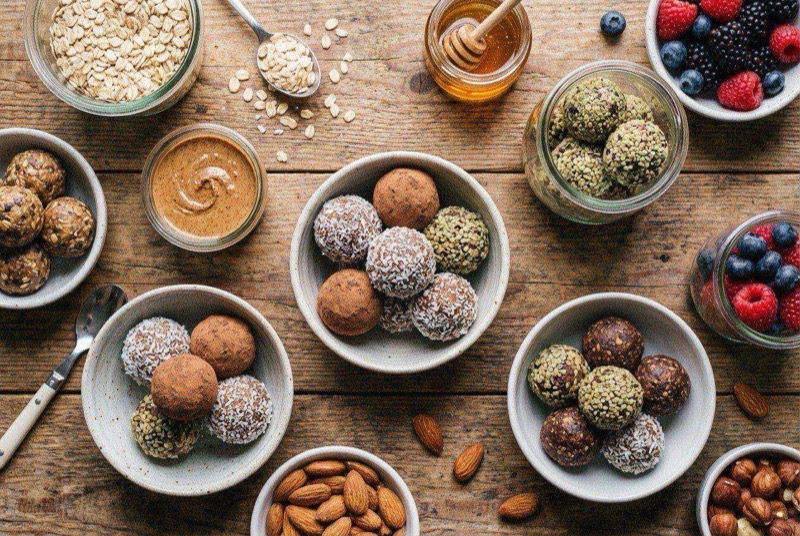 Round chocolate protein energy balls on parchment paper with mini chocolate chips visible