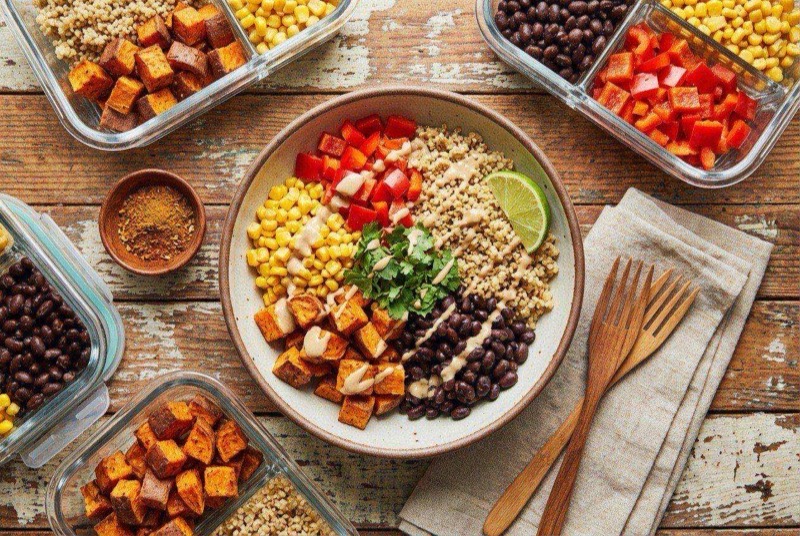 Colorful quinoa and black bean bowl with corn, red pepper, avocado slices, and fresh cilantro