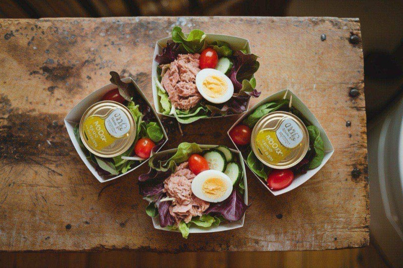 Bento box with tuna salad, cheese cubes, almonds, celery, and cherry tomatoes in separate compartments